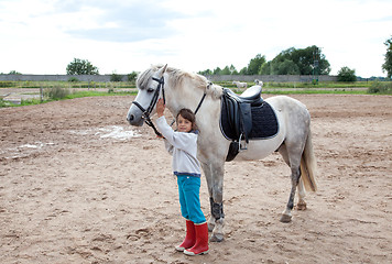 Image showing Little girl ready for a horseback riding lesson