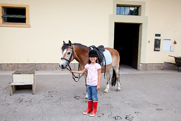 Image showing Little girl ready for a horseback riding lesson