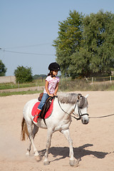 Image showing Little Girl Taking Horseback Riding Lessons