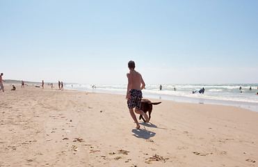 Image showing Dog and boy running.