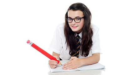 Image showing Bespectacled schoolgirl with long hair studying