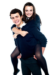 Image showing Girl riding piggyback and embracing boy tightly