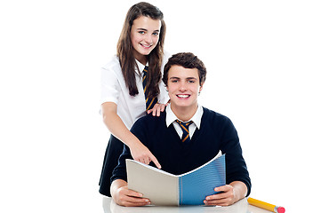 Image showing Girl pointing out the answer to her classmate