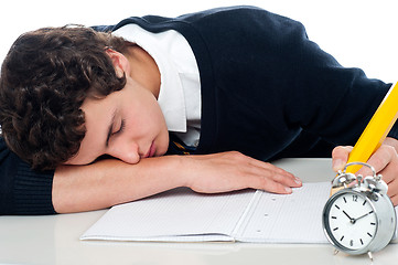 Image showing Teenager dozing off while writing his test