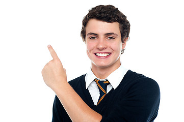 Image showing Handsome young boy in uniform indicating upwards