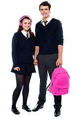 Image showing Boy holding pink backpack posing with female student