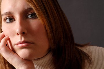 Image showing Closeup of an attractive young woman with her chin resting on he