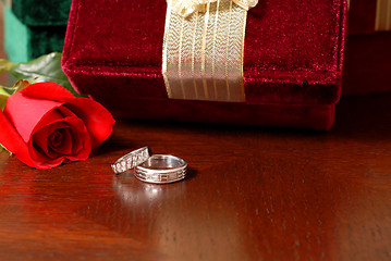 Image showing Wedding rings with Christmas gifts and a rose