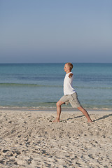 Image showing Man makes yoga sports on the beach portrait