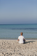 Image showing Man makes yoga sports on the beach portrait