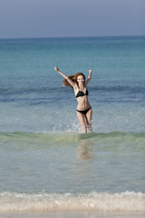 Image showing Woman with bikini in the sea jumping portrait