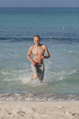 Image showing man running on the beach in water portrait