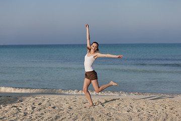 Image showing Woman cherfull jumping on beach landscape