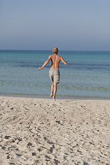 Image showing man running on the beach in water portrait