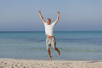 Image showing Cheerful man jumping on the beach laughing Landscape