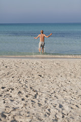 Image showing man running on the beach in water portrait