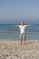 Image showing Man makes yoga sports on the beach portrait