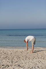 Image showing Man makes yoga sports on the beach portrait