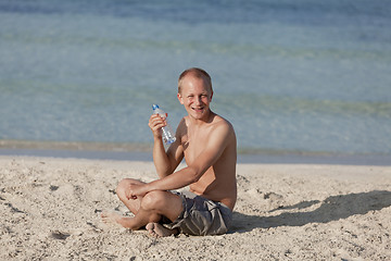 Image showing Man drinking water from a bottle on the beach landscape