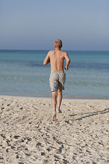 Image showing man running on the beach in water portrait