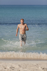 Image showing man running on the beach in water portrait