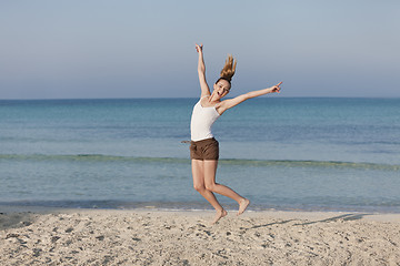 Image showing Woman cherfull jumping on beach landscape