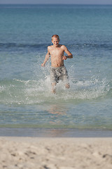 Image showing man running on the beach in water portrait