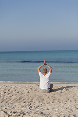 Image showing Man makes yoga sports on the beach portrait