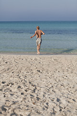 Image showing man running on the beach in water portrait