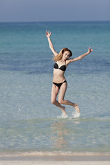 Image showing Woman with bikini jumping in the sea hochformat