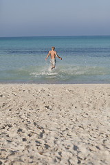 Image showing man running on the beach in water portrait