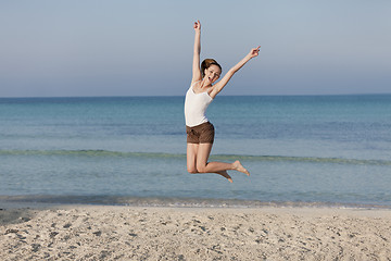 Image showing Woman cherfull jumping on beach landscape