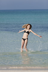 Image showing Woman with bikini jumping in the sea hochformat