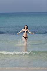 Image showing Woman with bikini in the sea jumping portrait