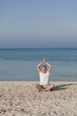 Image showing Man makes yoga sports on the beach portrait