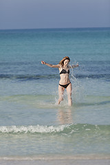 Image showing Woman with bikini in the sea jumping portrait