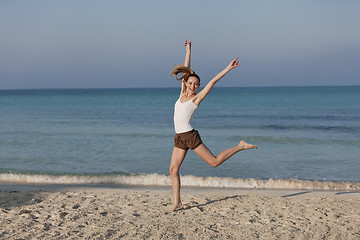 Image showing Woman cherfull jumping on beach landscape