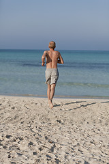 Image showing man running on the beach in water portrait