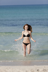 Image showing Woman with bikini in the sea jumping portrait