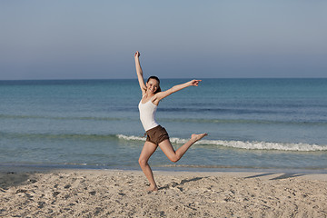 Image showing Woman cherfull jumping on beach landscape