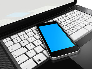 Image showing Mobile phone on a laptop