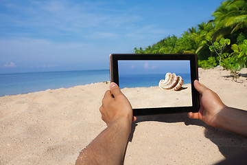 Image showing hands holding tablet pc on beach