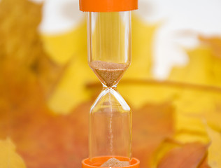 Image showing Background of autumn leaves and sandglass 