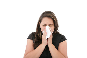 Image showing A woman with a cold or allergy wiping or blowing her nose. 