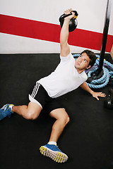 Image showing Young man doing kettlebell workout on gym