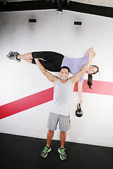 Image showing Handsome man lifting a beautiful woman at the gym 