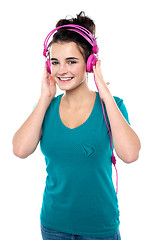 Image showing Cheerful pretty girl listening to music