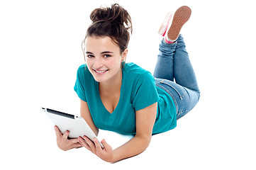 Image showing Causal teenager lying on floor holding new tablet pc
