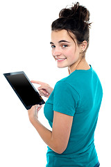 Image showing Trendy young casual girl operating tablet device