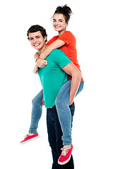 Image showing Handsome young man giving a piggyback ride to his girlfriend